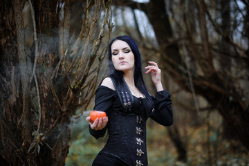 A woman in a witch suit in a forest