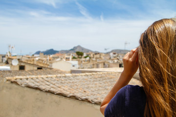 Fototapeta na wymiar Junge Frau über den Dächern von Alcudia Mallorca Spanien Touristin Ausblick