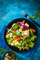 Green salad with chicken and vegetables top view.