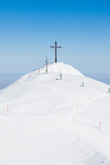 Obraz premium Untersberg Summit. The view across the summit of Untersberg mountain in Austria looking towards a cross. The mountain straddles the border between Germany and Austria.