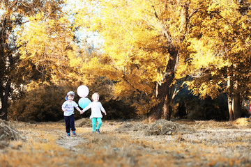 Little children are walking in autumn park