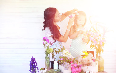 A young girl with a daughter is picking up a bouquet. A young mother with her daughter makes a...