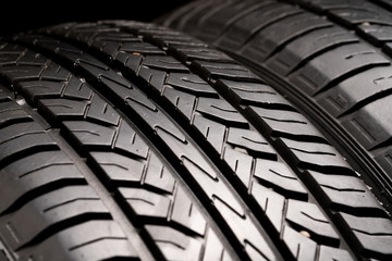 Protector close-up of old used summer tires. on black background.