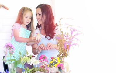 A young girl with a daughter is picking up a bouquet. A young mother with her daughter makes a...