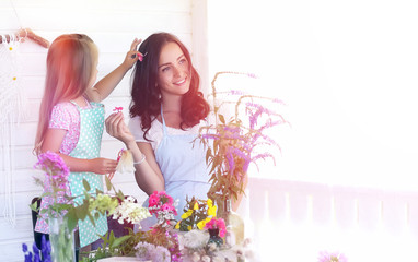 A young girl with a daughter is picking up a bouquet. A young mother with her daughter makes a...