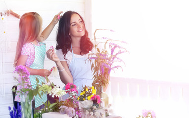 A young girl with a daughter is picking up a bouquet. A young mother with her daughter makes a...