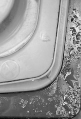 The edge of a lid of a household container after the rain in black and white