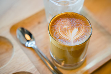 Latte coffee art served with a glass of water