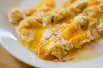 Medium cooked omeleted egg on the white plate.