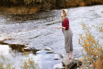 Girl in autumn with a fishing rod