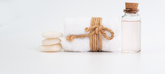 Spa wellness concept,rose liquid bottle soap,white towels and zen stones on white background