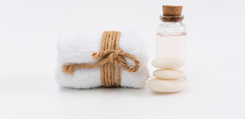 Obraz na płótnie Canvas Spa wellness concept,rose liquid bottle soap,white towels and zen stones on white background