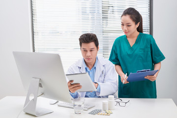 Group of doctors and nurses examining medical report of patient. Team of doctors working together on patients file at hospital.