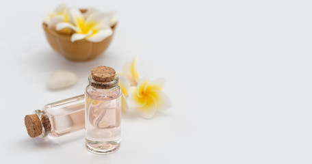 Spa wellness concept,rose liquid bottle soap,white stone and beautiful Plumeria flowers on white background