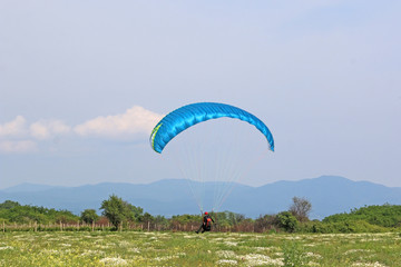 paraglider landing in a Meadow in Rose Valley, Bulgaria