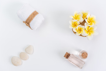 Fototapeta na wymiar Spa concept,white towels,rose liquid soap,Plumeria flower and zen stone over white background,top view with space for text