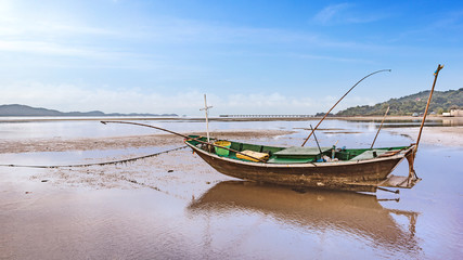 Obraz premium fishing boat docking on the sand bars in morning sunrise