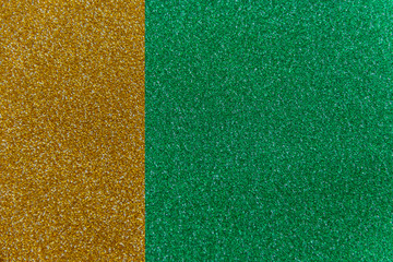 Golden and green sparkling background from small sequins, closeup. Brilliant shiny backdrop from textile. Shimmer paper