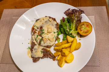 Close up photo of beef steak and creamy mushroom sauce 