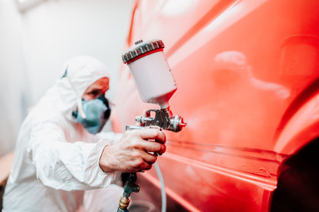 industry details - mechanic engineer using spray gun and painting a red car - Powered by Adobe