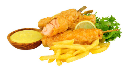 Battered salmon fish fillets on wooden skewers with French Fries with a wooden bowl of mayonnaise isolated on a white background