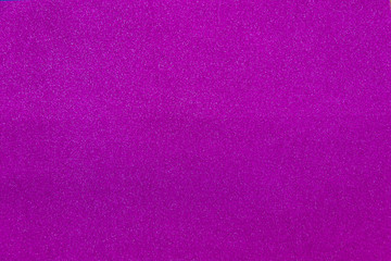 purple sparkling background from small sequins, closeup. Shimmer paper