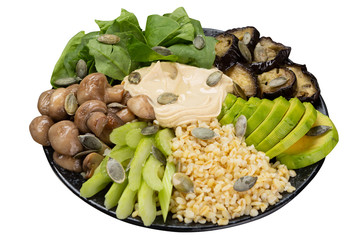bowl with healthy food, porridge and vegetables, hummus and mushrooms, avocado and eggplant, vegetarian