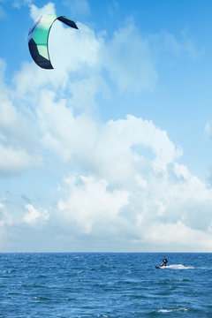 Kitesurfing riding over a surface of sea with a parachut. Summer