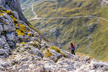 Woman tourist descending from Mangart (or Mangrt) peak towards Mangart saddle (Mangartsko sedlo)...