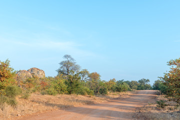 Autumn landscape with a gravel road and rocky outcrop