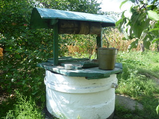 Fototapeta premium white rural well on the background of trees. screen saver on your desktop