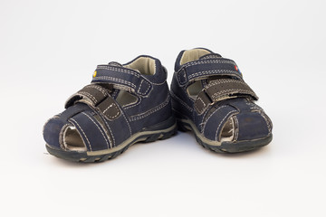 Old children's sandals in blue on a white background.