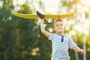 Happy 3 year old boy having fun playing with big plane outdoors