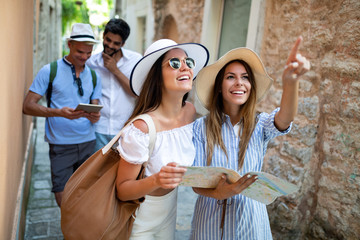 Happy group of friends tourists sightseeing in city on vacation