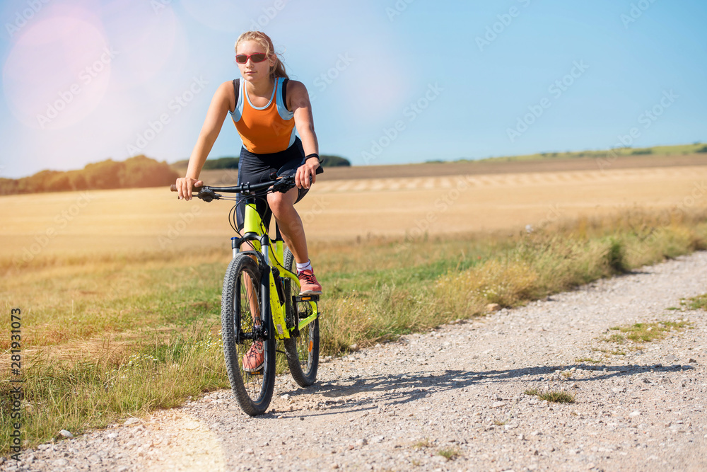 Wall mural beautiful athletic young woman doing mountain bike