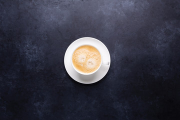 Cup of coffee on black stone background Top view