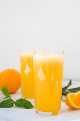 Two glasses of freshly squeezed orange juice on white background