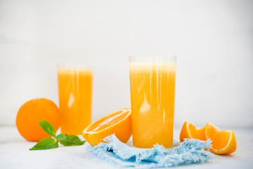 Two glasses of freshly squeezed orange juice on white background