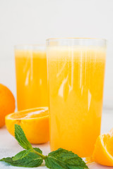 Two glasses of freshly squeezed orange juice on white background