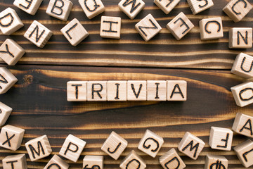 trivia - word from wooden blocks with letters, unimportant concept, random letters around, top view on wooden background