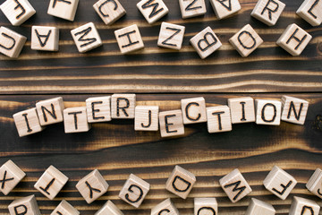 interjection - word from wooden blocks with letters, *** concept, random letters around, top view...