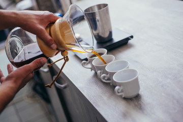 Barista pouring espresso coffe in his own coffe bar