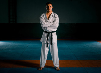 The karate guy in white kimono and black belt training karate