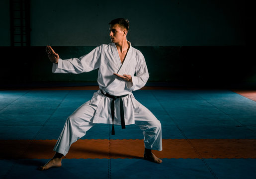The karate guy in white kimono and black belt training karate