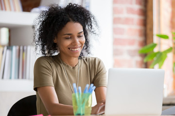 Attractive african businessman working typing on computer sitting at workplace
