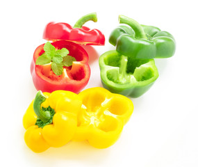 Freshness of Cut in half sweet peppers overlaid with mint, isolated on white background.