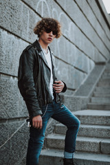 Obraz premium Serious curly man standing on stone stairs