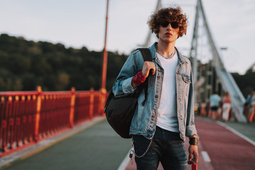 Obraz premium Young man with backpack is standing outdoors