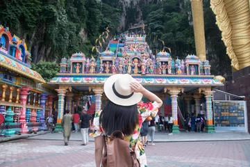 Foto op Aluminium Een toeristenvrouw bezoekt de Hindoese tempel van de Batu-grot in Kuala Lumpur, Maleisië. © BUSARA
