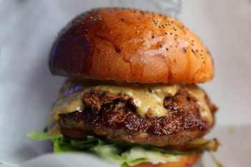 Juicy beef burger with cheese and herbs. Close-up